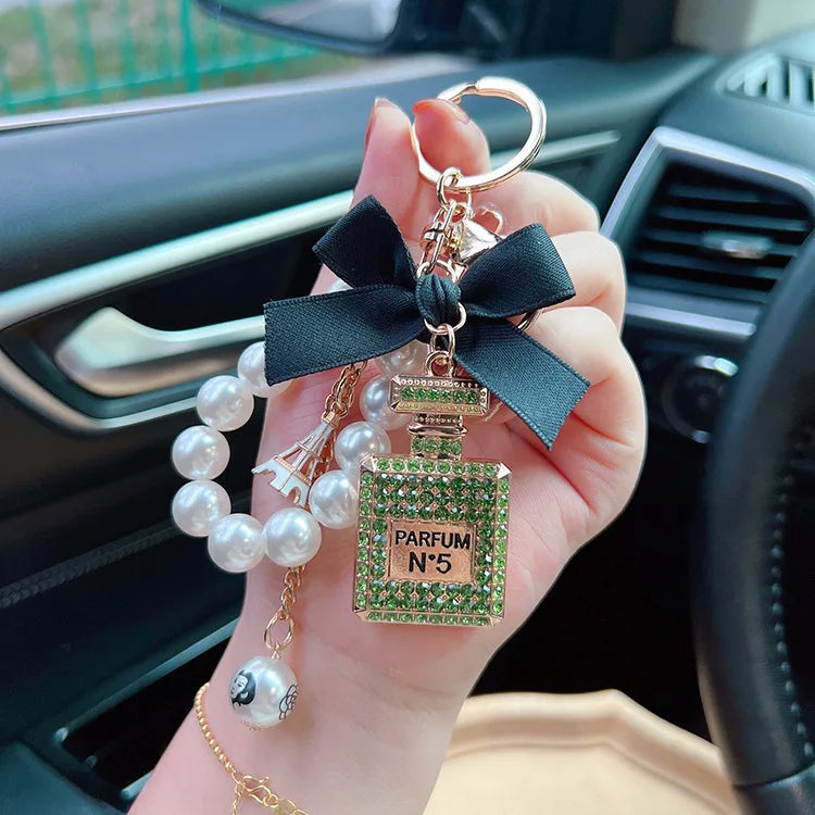 Alloy diamond inlaid bow shaped perfume bottle key chain creative pearl chain bag pendant exquisite key chain