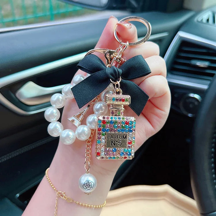 Alloy diamond inlaid bow shaped perfume bottle key chain creative pearl chain bag pendant exquisite key chain