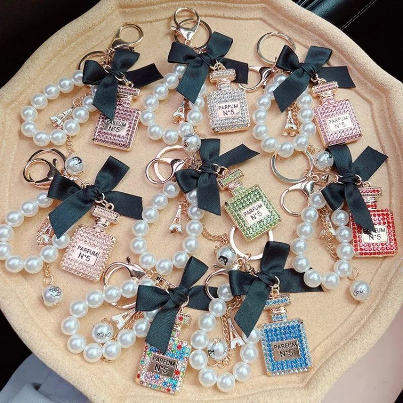 Alloy diamond inlaid bow shaped perfume bottle key chain creative pearl chain bag pendant exquisite key chain