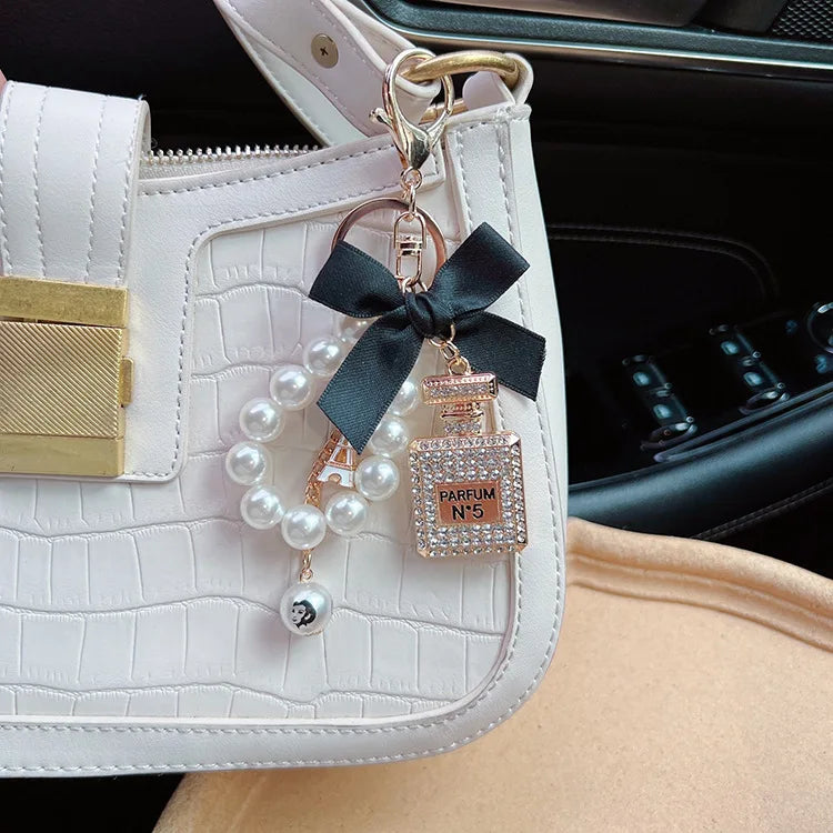 Alloy diamond inlaid bow shaped perfume bottle key chain creative pearl chain bag pendant exquisite key chain
