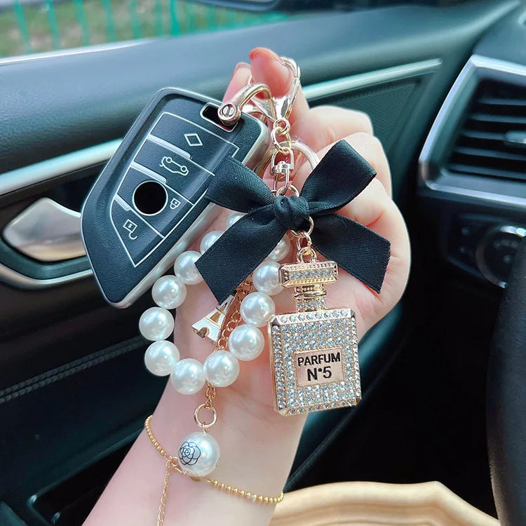 Alloy diamond inlaid bow shaped perfume bottle key chain creative pearl chain bag pendant exquisite key chain