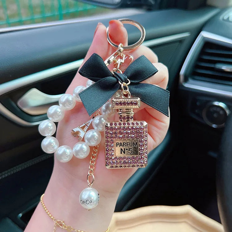 Alloy diamond inlaid bow shaped perfume bottle key chain creative pearl chain bag pendant exquisite key chain