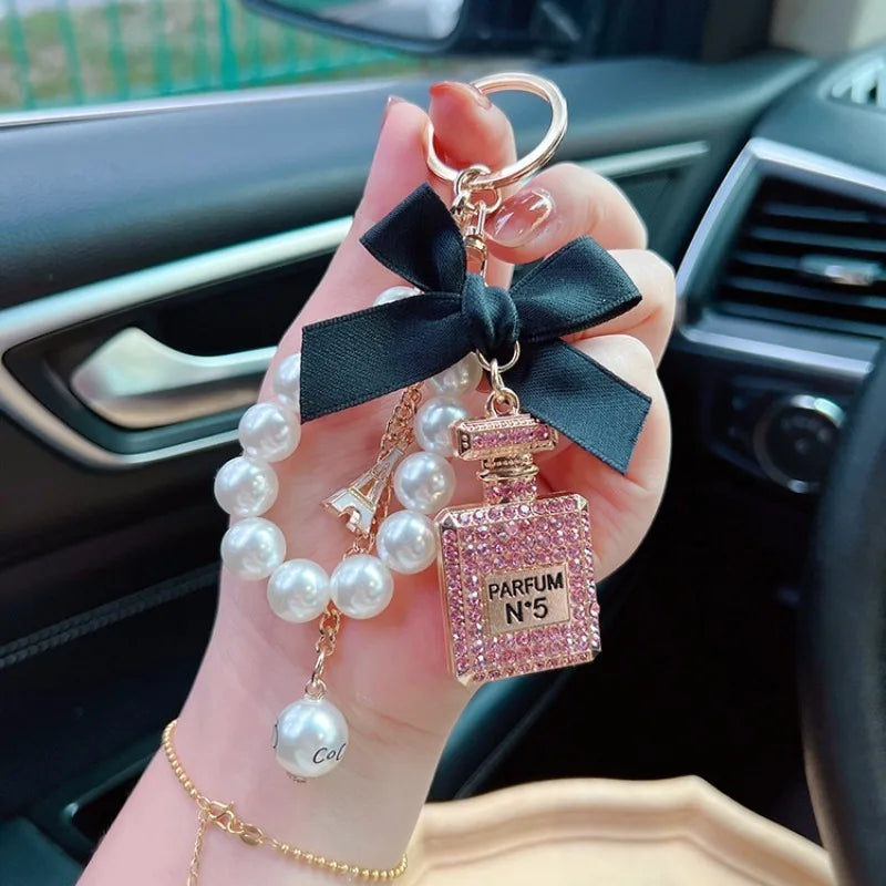 Alloy diamond inlaid bow shaped perfume bottle key chain creative pearl chain bag pendant exquisite key chain